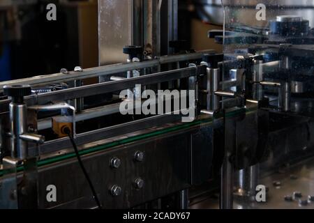 Trasportatore per il trasporto di bottiglie di vetro. Produzione e imbottigliamento di bevande alcoliche Foto Stock