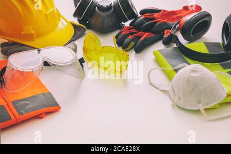 Attrezzatura di protezione per la sicurezza sul lavoro in piano. Dispositivi di protezione industriale su sfondo bianco, vista da primo piano. Concetto di salute e sicurezza del cantiere Foto Stock