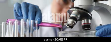 L'assistente di laboratorio versa il liquido per l'esame Foto Stock