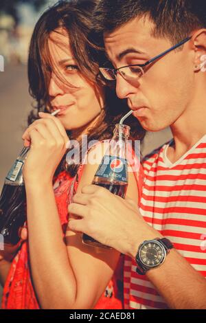 ODESSA, UCRAINA - 15 OTTOBRE 2014: Primo piano di giovane giovane felice giovane coppia adolescente all'aperto bere freddo Pepsi da bottiglie di vetro con paglia Foto Stock