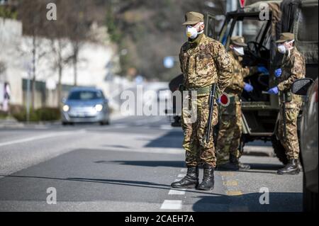 Soldati militari controllano la strada. Pattuglia di sicurezza con maschere e guanti per monitorare gli automobilisti che passano. Controllo giornaliero su strada per il Covid-19. Foto Stock