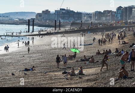 Brighton UK 6 agosto 2020 - la spiaggia di Brighton è affollata in una bella serata di sole come si prevede che le temperature raggiungeranno di nuovo al di sopra di 30 gradi nel Sud-Est di domani : Credit Simon Dack / Alamy Live News Foto Stock