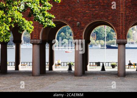 Stoccolma, Svezia - 31 luglio 2020: Vista dal cortile del municipio verso il lago Malaren attraverso la galleria con archi e colonne. Foto Stock