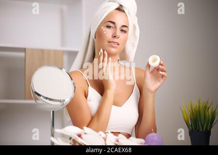 Giovane donna in un accappatoio, porta la bellezza nel bagno Foto Stock