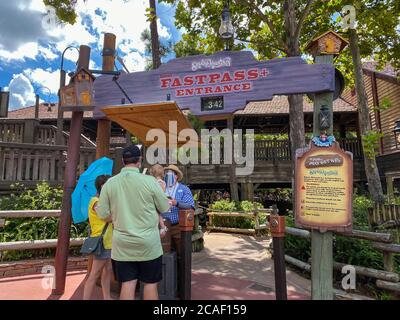 Orlando, FL/USA- 7/25/20: Persone che parlano con un membro del cast al giro di Splash Mountain indossando maschere facciali e divaricarsi sociale al Walt Disney World in Foto Stock