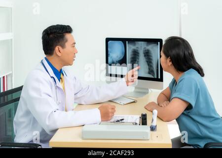 Medico asiatico uomo diagnosi medica dei polmoni e ha riferito cattive notizie per il cancro. Paziente che ascolta i risultati della scansione radiologica dal medico alla radiologia all'ospita Foto Stock