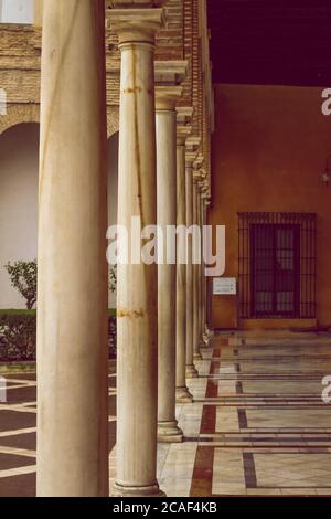 galleria di un cortile interno del Real Alcazar Gardens a Siviglia Spagna - natura e architettura sfondo Foto Stock