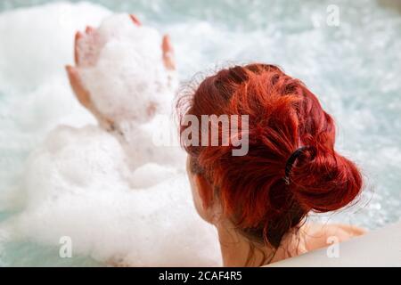 Ritratto di Pretty naturale rosso donna rilassante nella sua jacuzzi Foto Stock