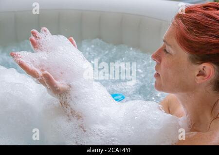 Ritratto di Pretty naturale rosso donna rilassante nella sua jacuzzi Foto Stock