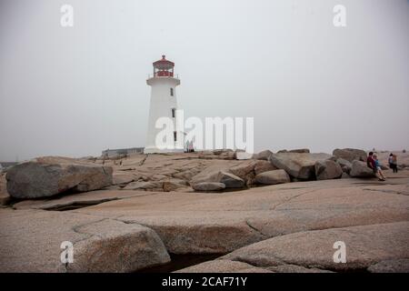 Halifax, Nuova Scozia: 19 luglio 2020: Una giornata estiva a Peggy's Cove durante la pandemia con alcuni turisti vicino al faro Foto Stock