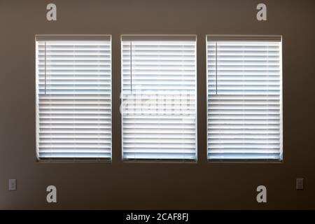 Tre finestre con finestre chiuse in legno bianco moderno faux come sfondo. Foto Stock