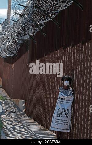 Nogales, Arizona, Stati Uniti. 6 agosto 2020. I membri dell'iniziativa Kino Border protestano per lo smantellamento dell'asilo al muro di confine di Nogales, Arizona. Save Asylum sentito dai richiedenti asilo, dai membri della società civile e dal clero di entrambe le parti del confine che protestano contro le amministrazioni Trump l’eliminazione del processo di asilo che essi affermano è contrario al diritto internazionale. Credit: Christopher Brown/ZUMA Wire/Alamy Live News Foto Stock