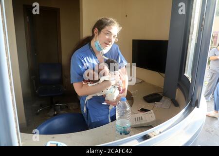 Pechino, Libano. 4 agosto 2020. Un'infermiera si prende cura di tre bambini in un ospedale danneggiato dopo l'esplosione a Beirut, Libano, 4 agosto 2020. Credit: Bilal Jawich/Xinhua/Alamy Live News Foto Stock