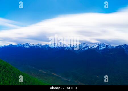 Le nuvole soffici si trovano in cima all'imponente catena montuosa delle Montagne Rocciose da High Scenic Viewpoint Foto Stock