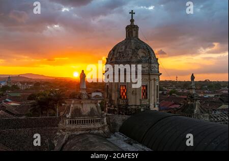 Cupola della chiesa la Merced a Granada al tramonto con sculture della Vergine Maria e lo skyline della città, Nicaragua. Foto Stock