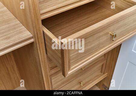 Cassetti in legno con manici dorati da vicino. Ripieno di legno di guardaroba. armadio in legno con ante laccate bianche Foto Stock