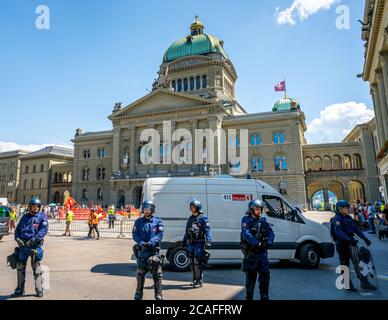 Berna Svizzera , 27 giugno 2020 : poliziotti svizzeri e pulmino di polizia in piazza federale di fronte al palazzo del parlamento federale a Berna Svizzero Foto Stock