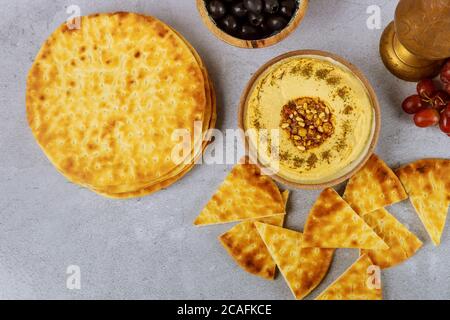 Tavolo da pranzo turco con pita pane, hummus e uva su sfondo bianco. Foto Stock