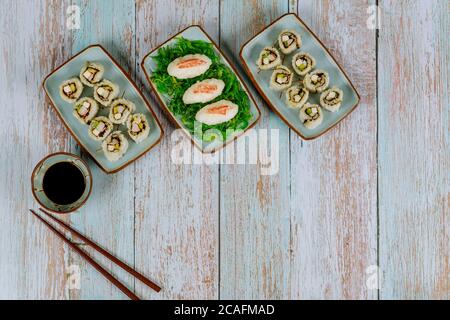 Set di sushi e roll di philadelphia con salsa di soia, zenzero e chopstick. Cucina giapponese. Foto Stock