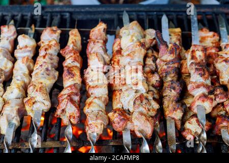 Cucina kebab alla griglia su spiedini di metallo. Grigliare con carbone e fiamma. Foto Stock