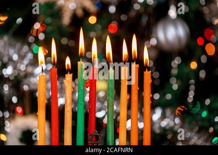 Menorah con candele brucianti per Hanukkah su sfondo scintillante con luci colorate sfocate. Festa ebraica. Foto Stock