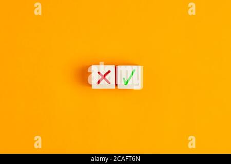 Segno di spunta e segno di croce x su cubi di legno. Concetto di decisione positiva o negativa o scelta di approvazione o rifiuto. Foto Stock