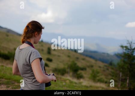 girl fotografo spara in alto in montagna Foto Stock