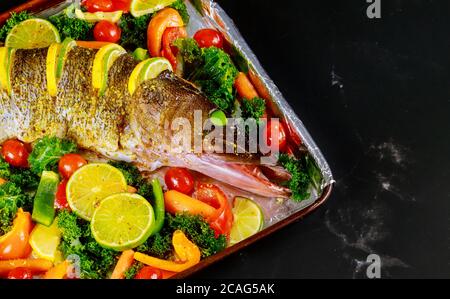 Un luccio fresco con verdure colorate e spezie sulla teglia da forno Foto Stock