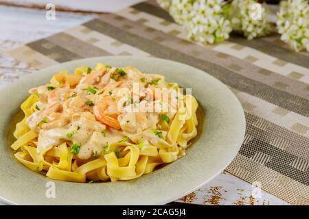 Pasta di fettuccine Alfredo con gamberi sul piatto . Primo piano. Foto Stock