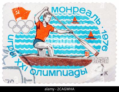 Timbro stampato in Russia (Unione Sovietica), Olimpiadi estive di Montreal, canoismo, atleta è nuotare in una barca con un dispositivo di compressione Foto Stock