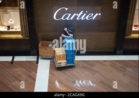 25.06.2020, Singapore, , Singapore - UN lavoratore sta aspettando nel centro commerciale Marina Bay Sands (The Shoppes) di fronte ad un lussuoso gioielliere Cartier Foto Stock