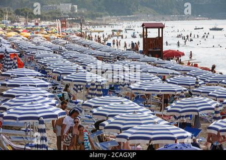 11.08.2018, Cefalu, Sicilia, Italia - Turismo di massa sulla spiaggia della città. I turisti si rilassano sotto gli ombrelloni e si bagnano nel Mar Mediterraneo. 00U180811D033CA Foto Stock