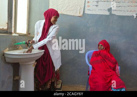 12.11.2019, DENAN, Regione somala, Etiopia - in una sala di trattamento dell'ospedale DENAN un medico le lava le mani in un lavello sotto l'acqua corrente. Avanti t Foto Stock
