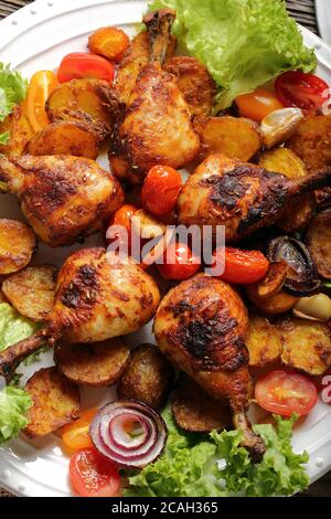 Arrosto di cosce di pollo con patate al forno sulla piastra Foto Stock