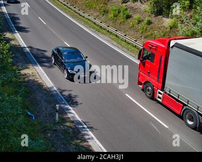 Der Blick auf die Bundesstraße B27 a Stoccarda. Ein Tesla Model S und ein LKW am fahren. Foto Stock