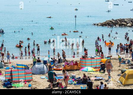 Lyme Regis, Dorset, Regno Unito. 7 agosto 2020. Regno Unito Meteo: Folle di turisti e beachgoers accorrono alla spiaggia piena presso la località balneare di Lyme Regis per godersi il sole caldo e bruciante il giorno più caldo dell'anno. Le temperature di ricerca sono destinate a rompere i record quando l'ondata di caldo del Sahara colpisce la costa meridionale con l'Ufficio MET che emette un avvertimento ambrato di salute per il calore estremo. Credit: Celia McMahon/Alamy Live News Foto Stock