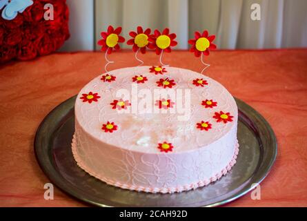 Torta grande decorata con frutti di bosco e fiori con un compleanno Foto Stock