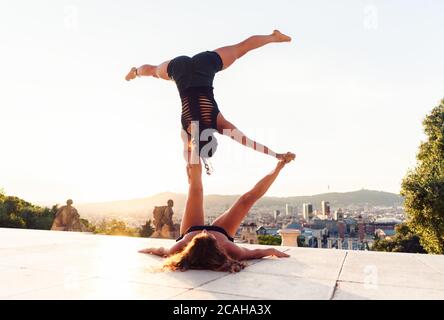 Due belle donne che fanno acroyoga in città Foto Stock