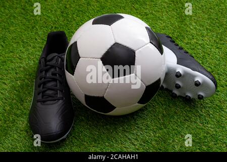 Attrezzatura sportiva, competizione atletica e concetto di evento sportivo con palla da calcio, scarpe da calcio in pelle o scarpe da calcio su erba verde Foto Stock