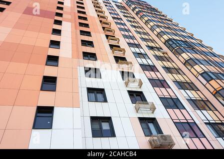 Parte della facciata di un edificio residenziale a più piani, vista dal basso. Primo piano. Foto Stock