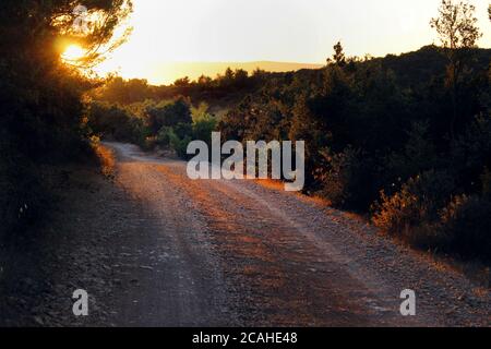 Strada ghiaiata al tramonto Foto Stock