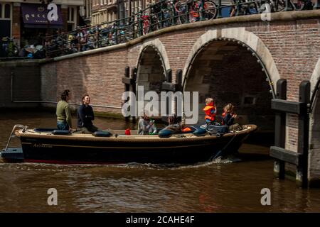 Amsterdam, Olanda, 05/15/2010: Primo piano immagine di una famiglia con bambini e adulti su una piccola barca fluviale in un canale di Amsterdam. La barca è ab Foto Stock