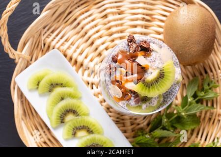 Concetto di cibo sano Bio Chia pudding con kiwi frutta e cioccolato muesli con spazio copia Foto Stock