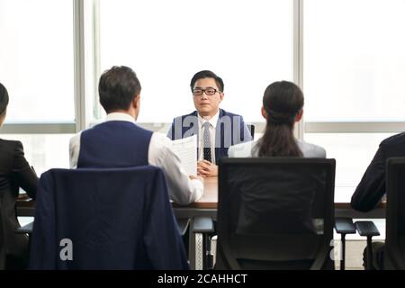 candidato di lavoro asiatico maschile intervistato da un gruppo di uomini d'affari Foto Stock