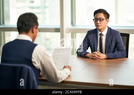 giovane asiatico intervistato dal responsabile delle risorse umane aziendali Foto Stock