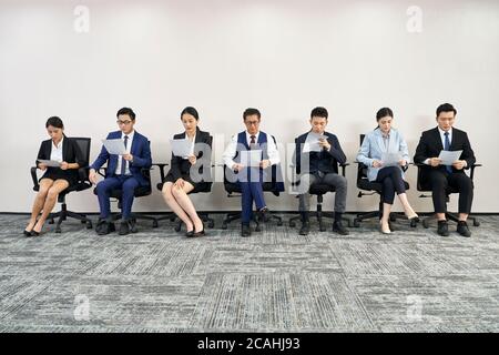 gruppo di uomini e donne d'affari asiatici in attesa di colloquio di lavoro in linea Foto Stock