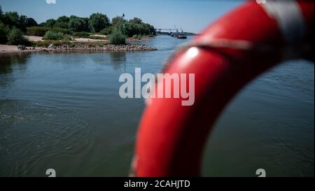 Duisburg, Germania. 07 agosto 2020. La gente siede sul Reno vicino al molo del traghetto Walsum-Orsoy. Credit: Fabian Strauch/dpa/Alamy Live News Foto Stock