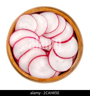 Fette di ravanelli rossi in ciotola di legno. Ravanelli estivi europei, Raphanus sativus, con pelle rossa e polpa bianca, tagliati a pezzi a forma di disco. Primo piano, fr Foto Stock
