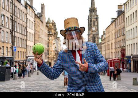 Edimburgo, Scozia, Regno Unito. 7 agosto 2020. In quello che sarebbe stato il giorno di apertura del 2020 cancellato Edinburgh Fringe Festival, Street performer e mago, Dr Love si prepara a intrattenere il pubblico sul Royal Mile nella città vecchia. Indossava i DPI e osservava rigide regole di allontanamento sociale e si esibiva all'interno di un'area defilata per evitare la formazione di folle. Iain Masterton/Alamy Live News Foto Stock