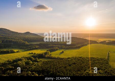 Sole che splende su colline boscose di piccoli carpazi in estate sera Foto Stock